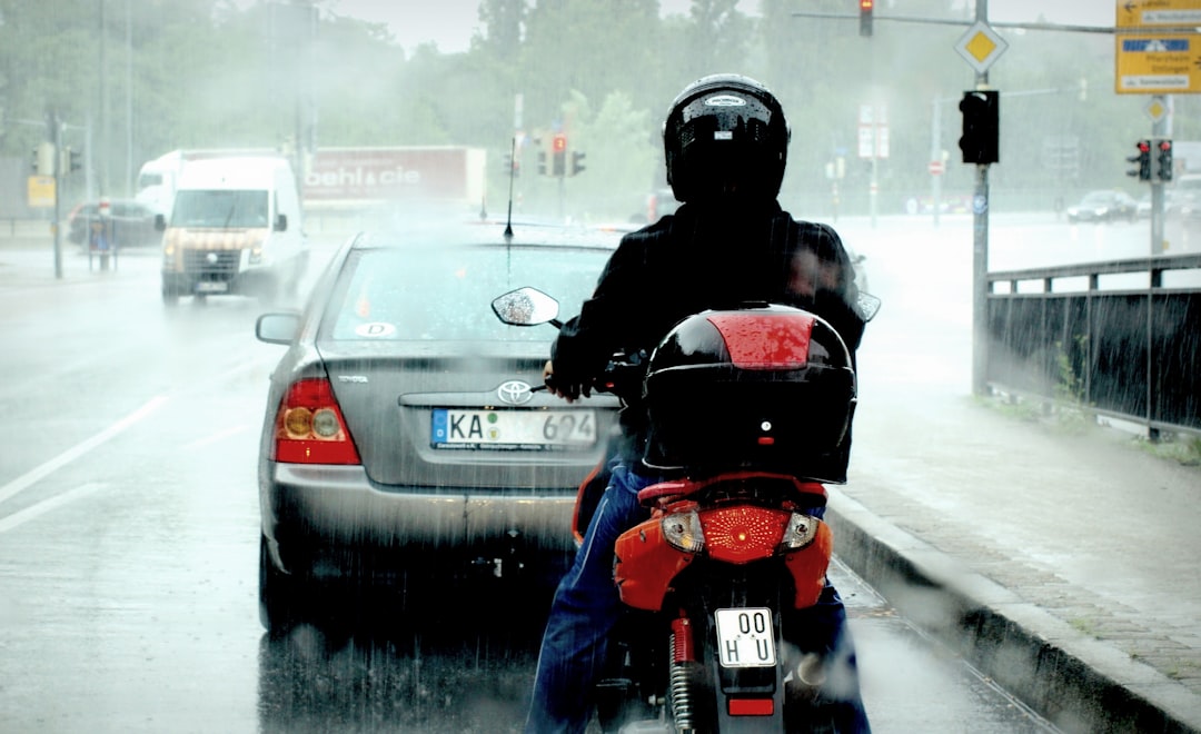 motociclista conduciendo en carretera mojada bajo lluvia